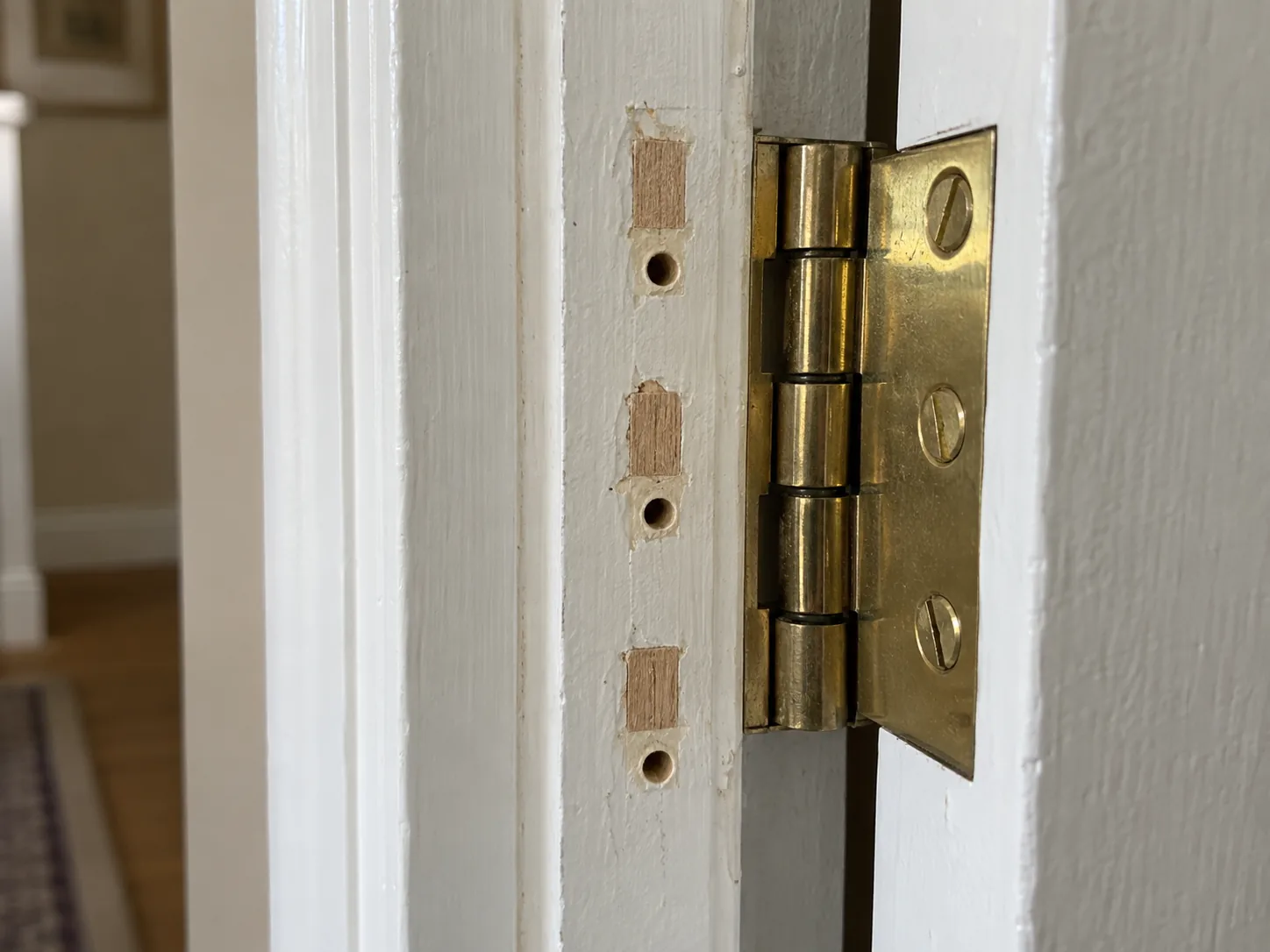 Hardwood slivers fitted into old hinge screw holes before redrilling