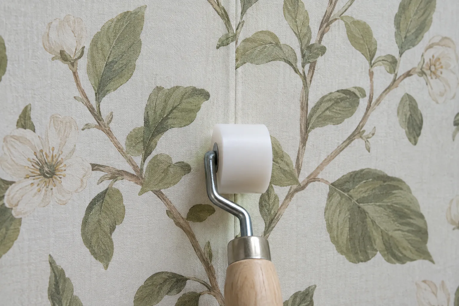 Repaired wallpaper seam pressed flat with a clean seam roller
