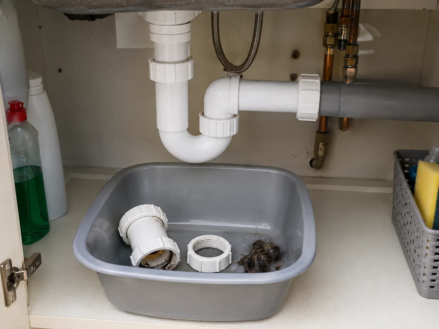 Clean sink trap components laid out for inspection beside a basin