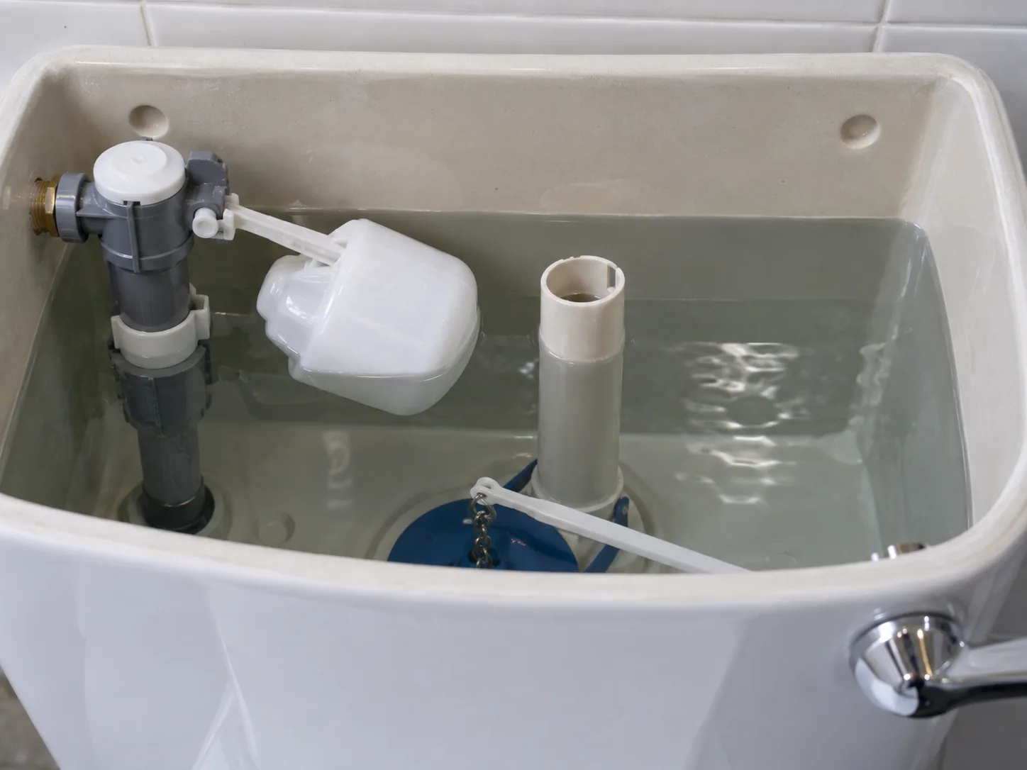 Close view of a toilet cistern float valve and overflow tube