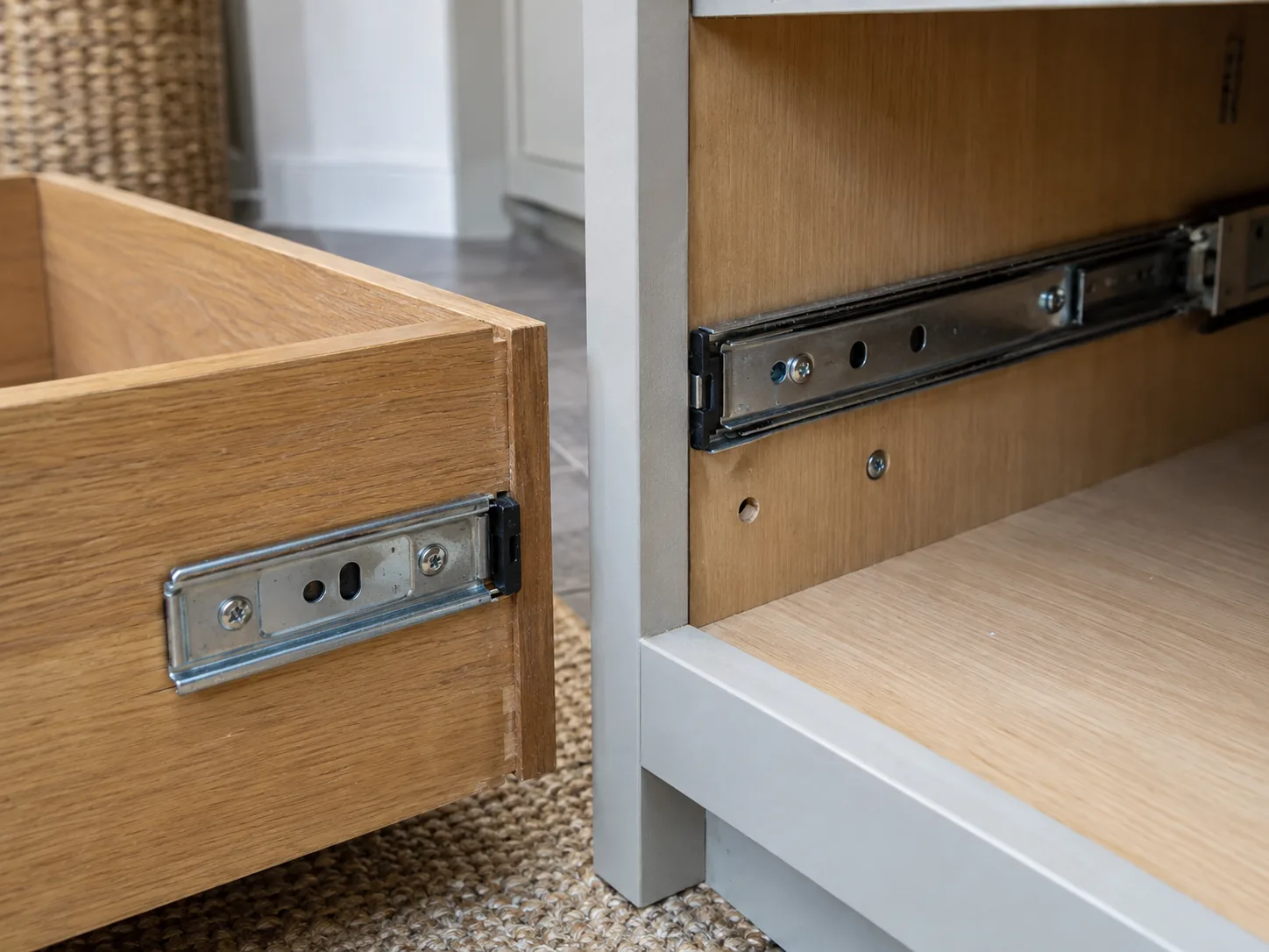 Drawer removed to show a ball-bearing runner and loose fixing hole in a cabinet